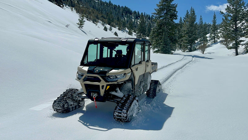 Tracked UTV climbing in deep snow